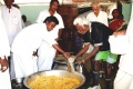 The political leader of the village distribut the meal to the students