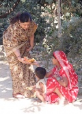 Mrs Raman give a Banana to a child in the colony .JPG