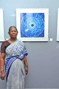 Bindu Artist Maligai stands proudly beside her painting