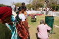 Students watching Daniel Fillod painting the waste bin